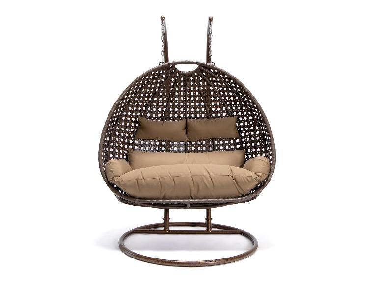 Wicker hangstoel met bruine kussens op een witte achtergrond