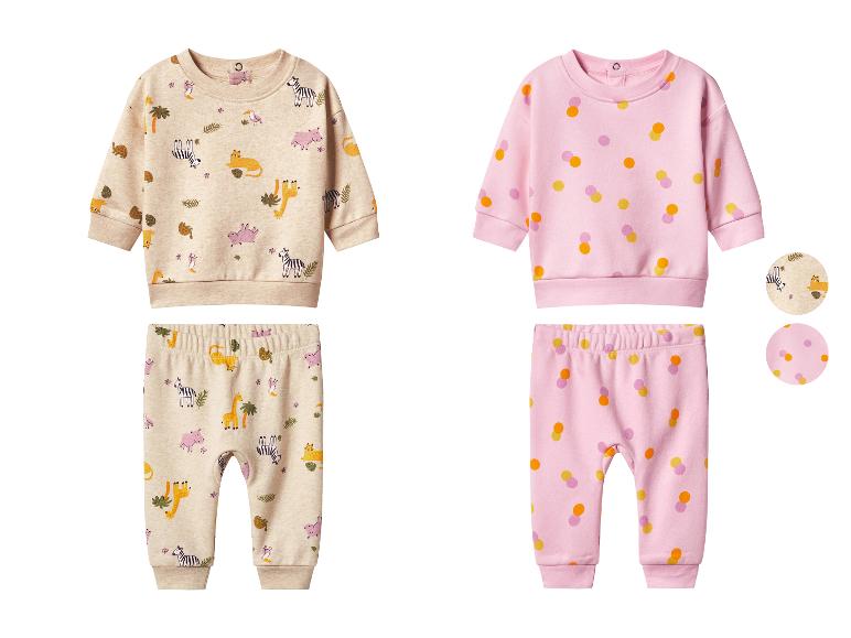 Twee babyoutfits, één beige met een jungle-dierenpatroon en één roze met kleurrijke stippen.