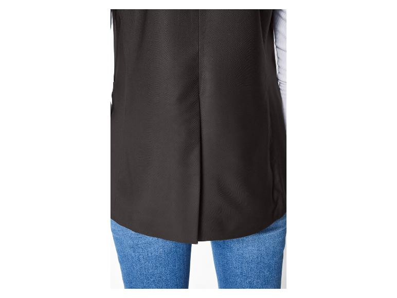 Zwart damesvest met blauwe jeans.