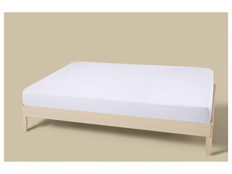 Wit matras op een houten bedframe