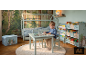 Kinderkamer met huisbed, tafel en stoelen, boekenkasten en opbergdoos, bosthema.