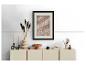 Moderne ladekast met decoraties: ingelijste afbeelding, vaas met gedroogde bloemen en kandelaars.