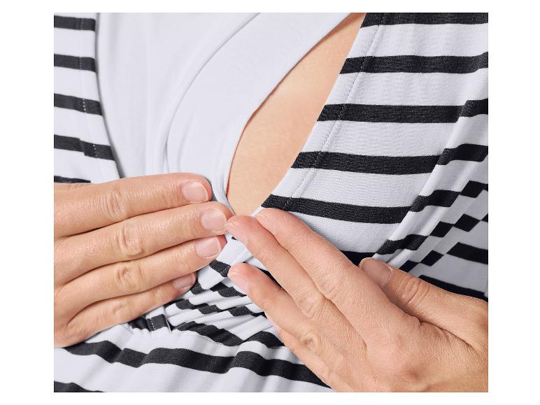 Close-up van de handen van een vrouw die een gestreepte zwangerschaps- en borstvoedingstop aanpast.