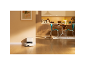 Robotstofzuiger met laadstation in een moderne keuken met een kat.