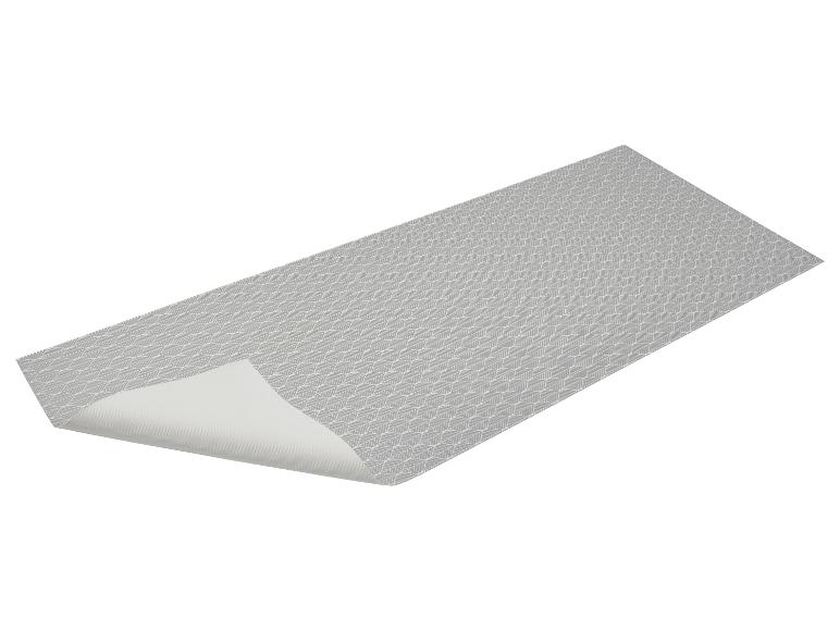 Grijze placemat met bladerenpatroon, aan één kant gevouwen