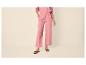 Roze wijde broek voor dames met zwarte platte sandalen.