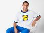 Wit Lidl t-shirt met contrasterende kraag en blauwe broek.