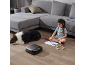 Robotstofzuiger op een houten vloer met een tekenend kind en een slapende hond.