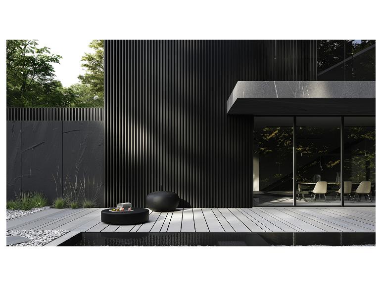 Modern buitenterras met zwarte meubels en groene planten.