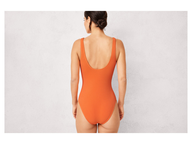 Een vrouw in een oranje badpak.