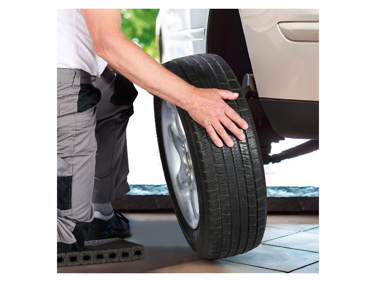 Monteur verwisselt een autoband, met de hand op de band.