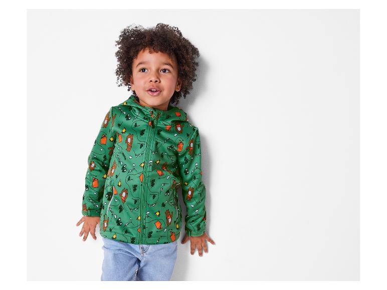 Een peuter in een groen softshell jack met campingprint.