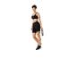 Vrouw in zwarte sportkleding met hoofdband, sportbeha, fietsbroek en waterfles.