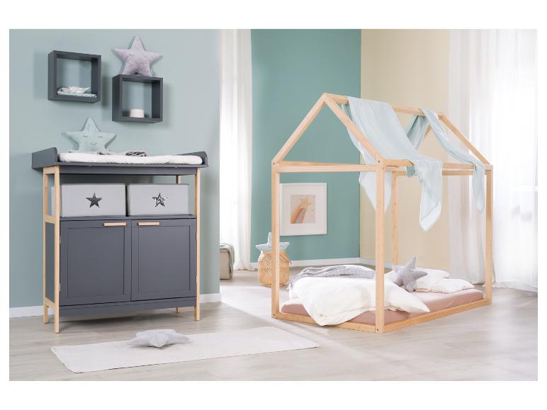 Kinderkamer met commode en houten huisbed.