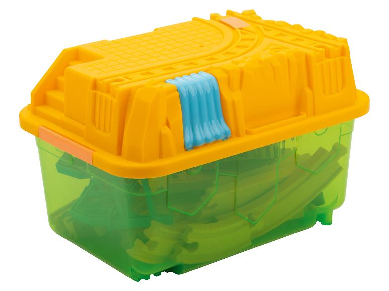 Gele en groene opbergdoos met speelgoedtreinonderdelen.