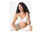 Vrouw in witte bh en slip, zittend en lachend.