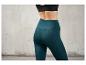 Een vrouw draagt ​​donkergroene leggings.