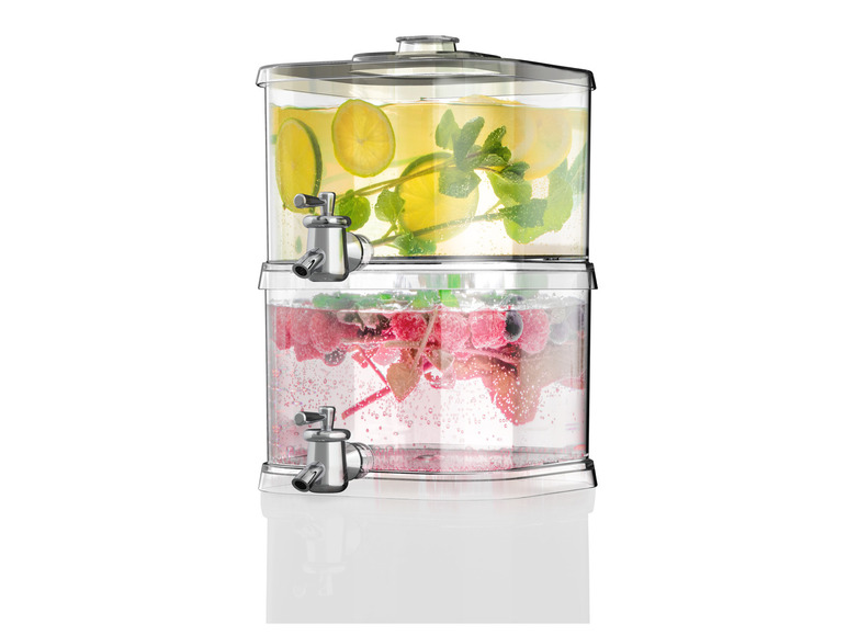 Een glazen dispenser met kraan, gevuld met water, citroen en bessen.