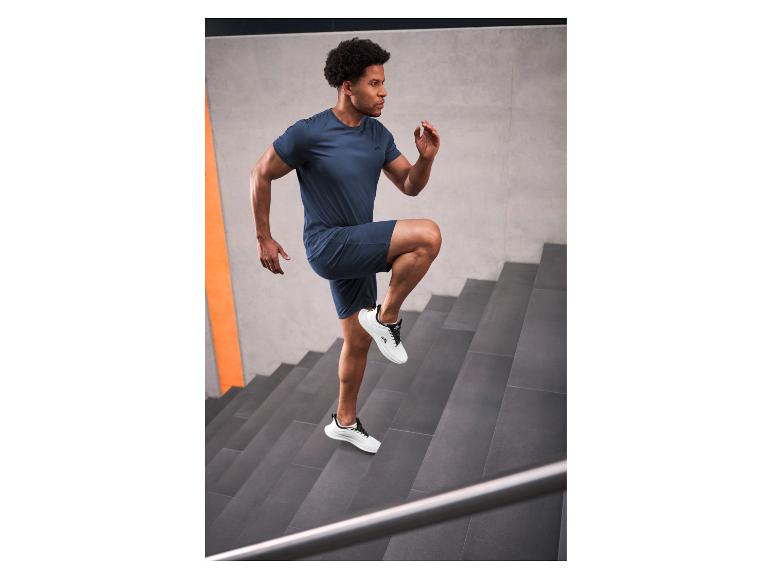 Man in marineblauwe sportkleding die trappen oploopt
