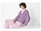 Model met een paarse gebreide cardigan en roze broek.