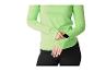 Vrouw in groene sporttop en zwarte legging, controleert een smartwatch.