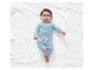Baby in een lichtblauwe romper met dierenprint.