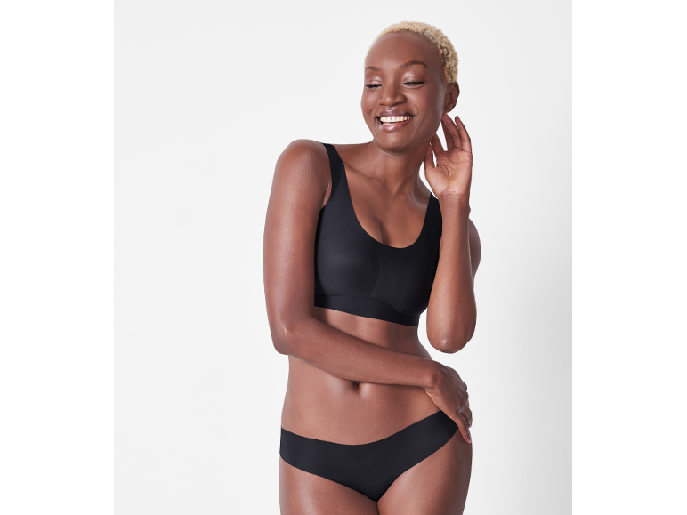Vrouw in een zwarte, naadloze bh en slip.