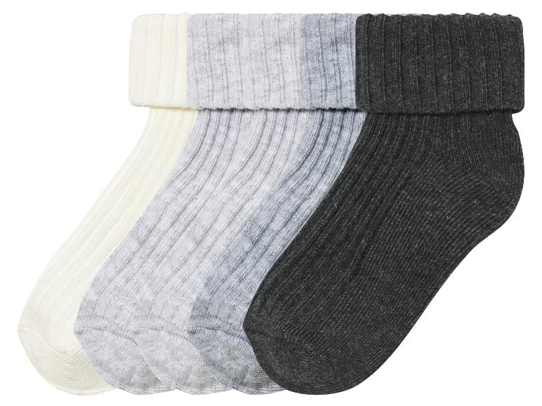 Drie paar sokken in de kleuren wit, grijs en zwart.