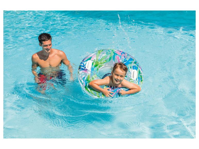 Een kind geniet in een zwembad op een transparante zwemband met tropische print.