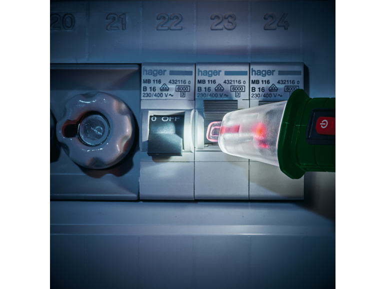 Een elektricien gebruikt een Hager spanningstester om een ​​elektrisch paneel te controleren.