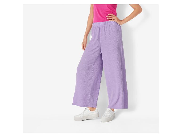 Lila wijde broek en witte sneakers: een casual en stijlvolle look.