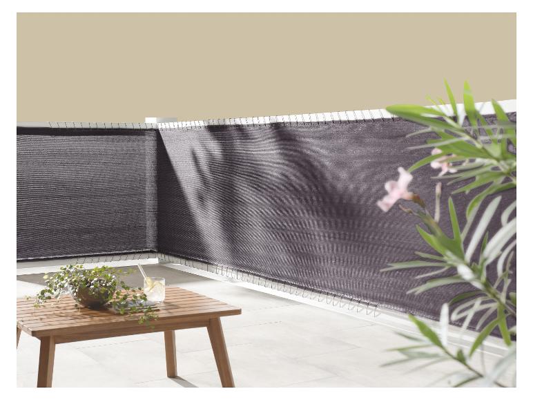 Donkergrijs balkonscherm met houten tafel en planten.
