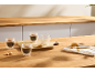 Dubbelwandige glazen espressokopjes met koekjes op een houten tafel.
