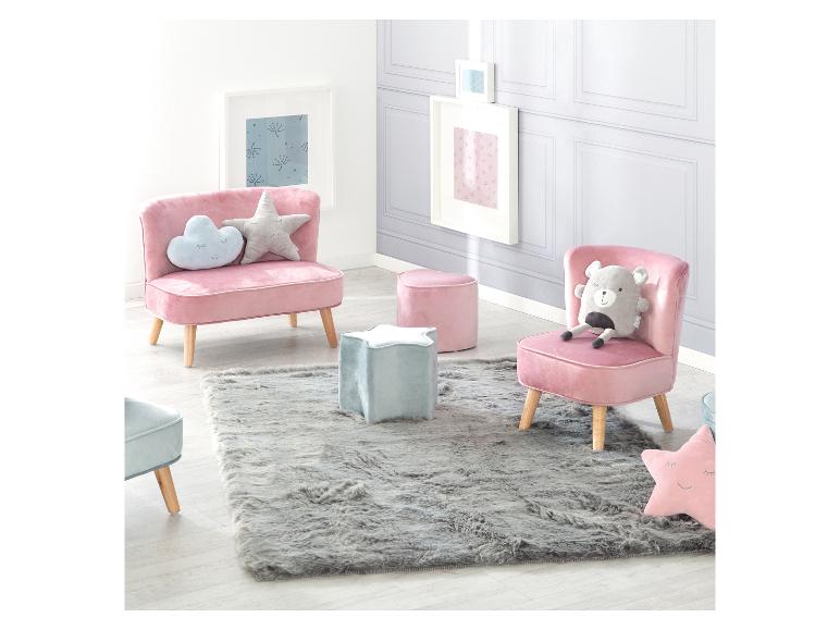 Kinderkamer met roze stoelen, poefs en grijs tapijt.