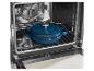 Blauwe gietijzeren braadpan in een open oven op een rooster.