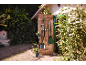 Tuin gereedschap hangend aan een houten deur, met een schop en hark op de voorgrond.