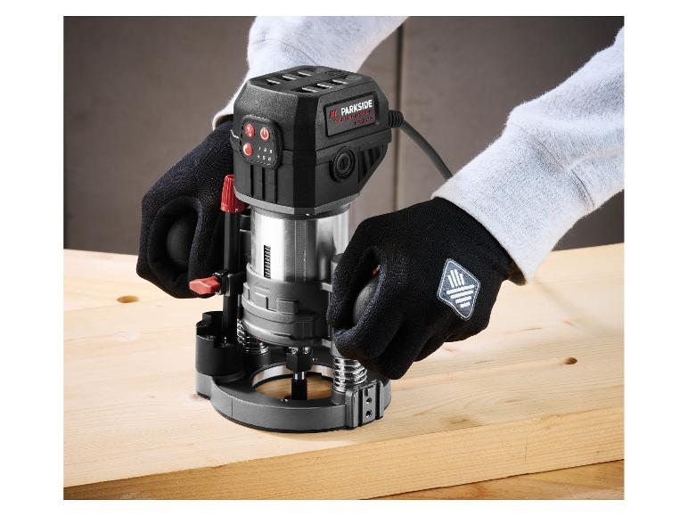 Persoon gebruikt een zwarte Parkside Performance bovenfrees op een houten plank