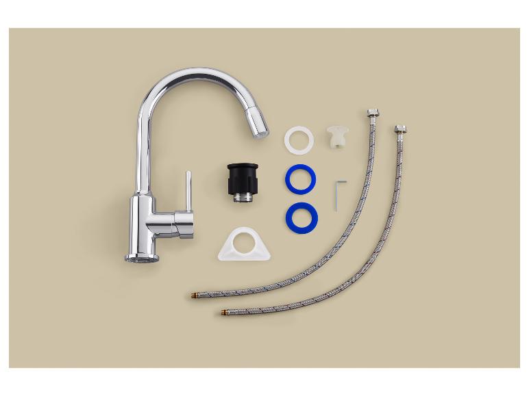 Chromen keukenkraan met installatieaccessoires op een beige achtergrond.