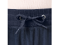 Close-up van marineblauwe velours joggingbroek met trekkoord in de taille en een lichte geribbelde top.