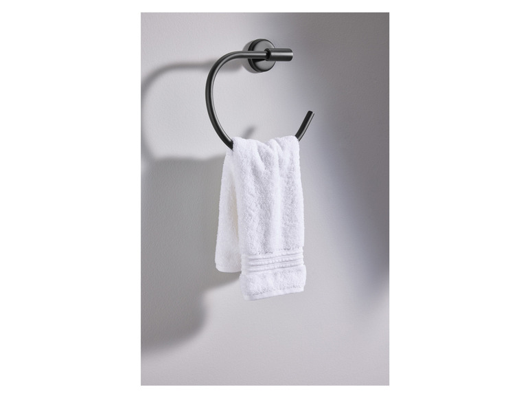 Een handdoek hangt aan een zwarte handdoekring.
