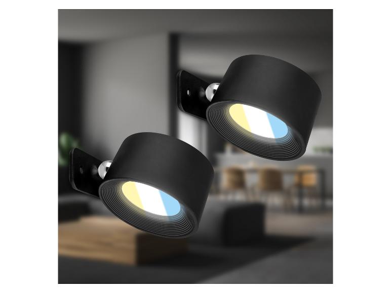 Twee zwarte wandspots met warm en koel licht in een modern interieur.