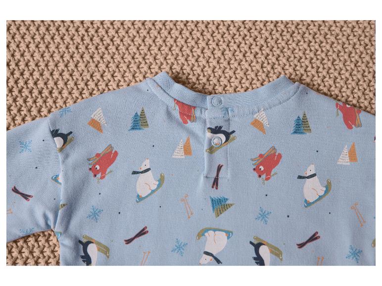 Een blauwe babytrui met pinguïns, beren en ski's.