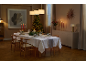 Feestelijk gedekte eettafel met kerstdecoratie in een sfeervolle kamer.