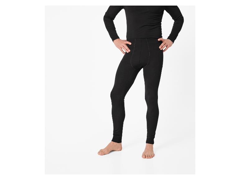 Man in zwarte legging en shirt met lange mouwen, met handen in de zij.