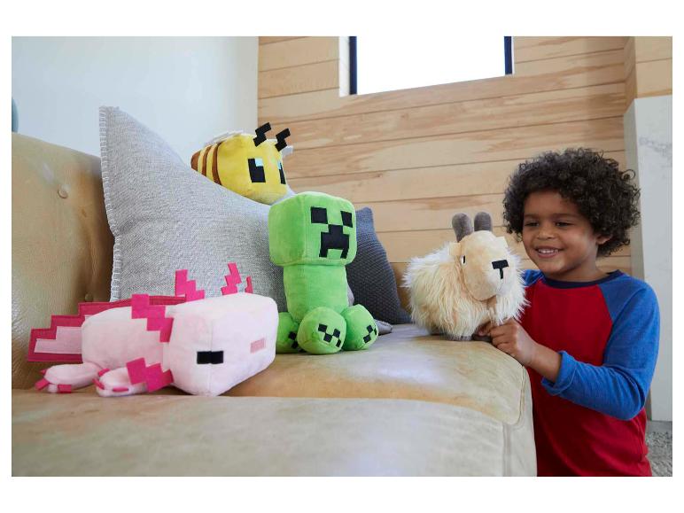 Lachende jongen met Minecraft knuffels: axolotl, bij, Creeper en geit.