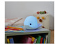 Een blauwe walvis nachtlampje op een groene tafel met kleurpotloden en boeken.