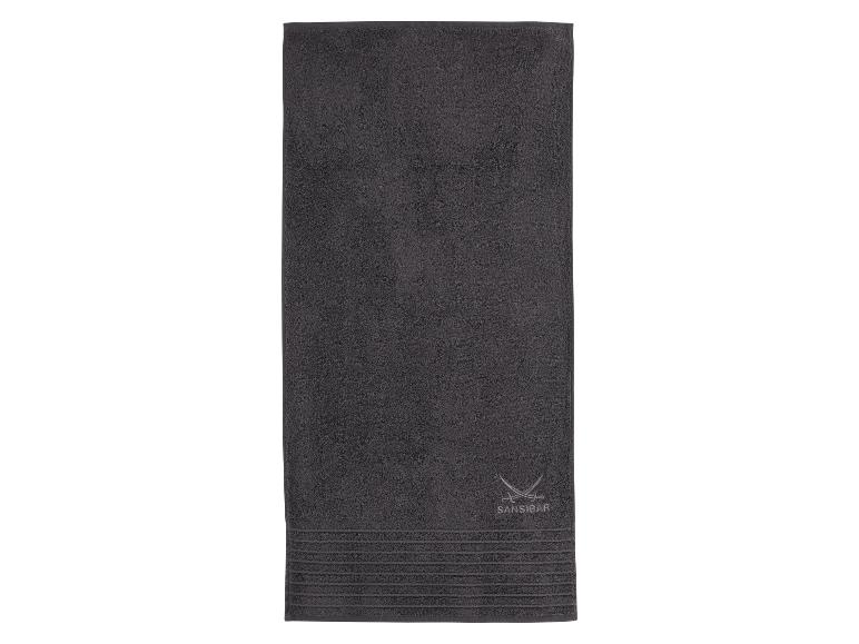 Donkergrijze Sansibar handdoek met geborduurd logo en decoratieve strepen.