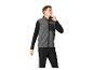 Man in grijs fleecevest met zwarte mouwen en zwarte broek.