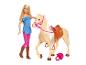 Blonde Barbiepop in roze en blauw, naast een beige paard met zadel.