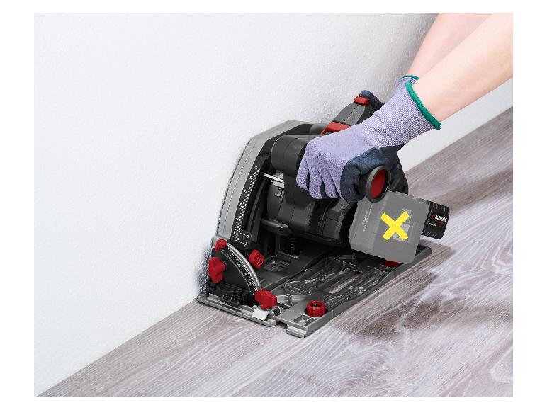 Een persoon met handschoenen houdt een accudompelzaag vast, klaar om laminaatvloer te zagen.